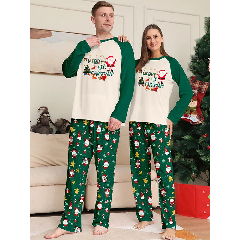 Two people wearing matching Christmas-themed pajamas in a living room setting.