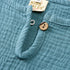 Close-up of teal fabric with a button and 'Kids Sales' tag.
