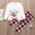 Children's Christmas-themed outfit with reindeer design on a white shirt and plaid pants on a wooden surface.