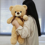 Person holding a large teddy bear in an indoor setting