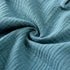 Close-up of textured teal fabric with a swirl pattern