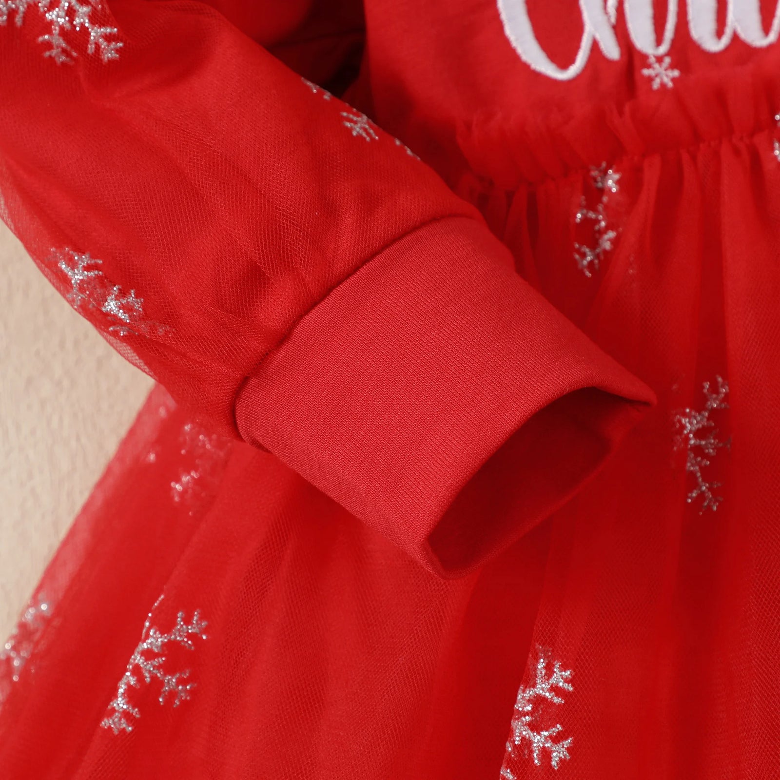 Red dress with snowflake patterns and white text on a beige background