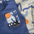 Blue tank top with 'Cool Vibes' graphic and beige patterned shirt next to it.