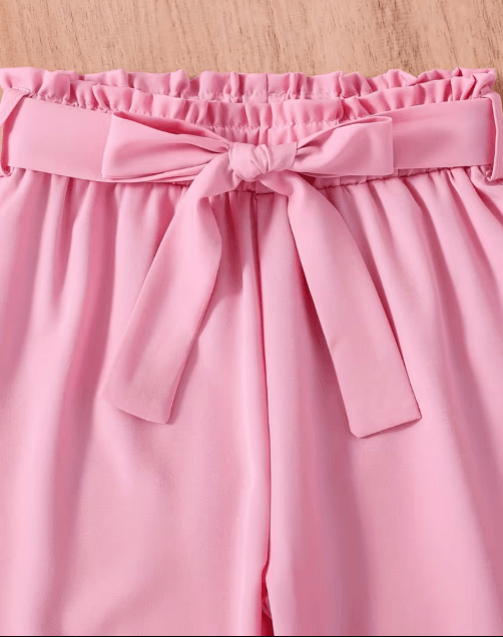 Pink skirt with a bow detail on a wooden surface