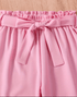 Pink skirt with a bow detail on a wooden surface
