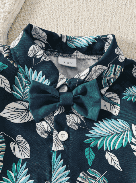 Children's outfit with leaf pattern and bow detail on a neutral background