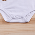 White baby onesie on a wooden surface