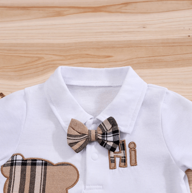 White shirt with plaid bow tie and bear design on a wooden surface