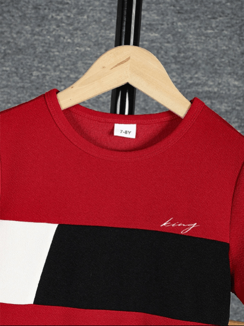 Red and black crop top with 'king' embroidery on a hanger against a gray background