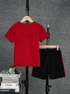 Red t-shirt and black shorts on hangers against a gray textured background