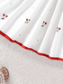 White fabric with red floral embroidery on a textured white surface