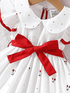 White dress with red bow and floral patterns on a hanger
