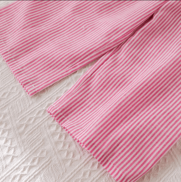 Close-up of pink striped fabric on a textured surface