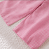 Close-up of pink striped fabric on a textured surface