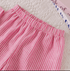 Close-up of pink and white striped pants on a textured surface