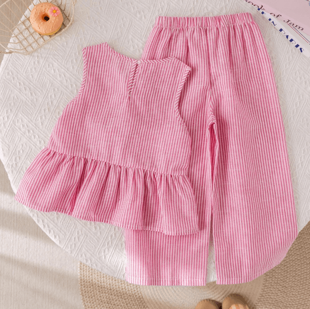 Pink striped top and pants on a textured surface with a donut in the corner.