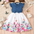 Children's dress with blue top and floral skirt on a textured surface with flowers and butterflies.