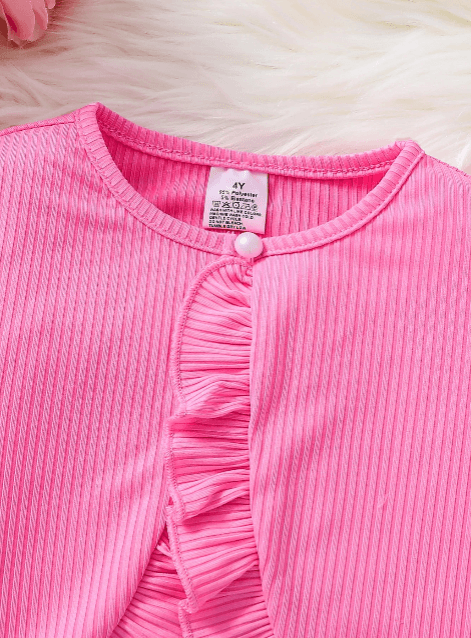 Close-up of a pink ribbed garment with ruffled details on a white background