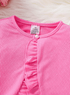 Close-up of a pink ribbed garment with ruffled details on a white background