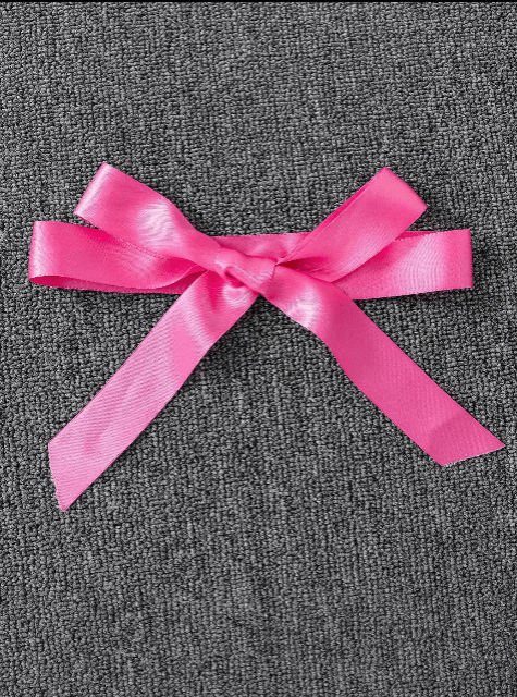 Pink ribbon bow on a gray textured background