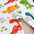 Fabric with colorful dinosaur pattern on a white background