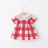 Red and white checkered dress with cherry collar on a hanger against a white background