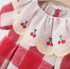 Red and white checkered dress with cherry embroidery on a hanger