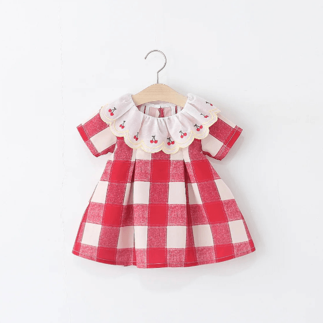 Red and white checkered dress with ruffled collar on a hanger against a white background