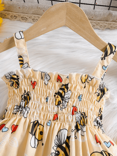 Beige dress with bee and heart pattern on a wooden hanger
