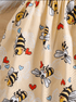 Beige fabric with cartoon bee and heart pattern