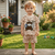 Child wearing a patterned outfit with a bear design in a backyard setting