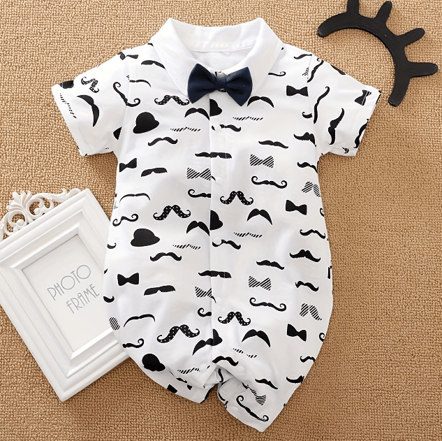 Baby romper with mustache and bow tie pattern on a textured surface