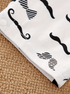 White towel with black mustache patterns on a textured surface