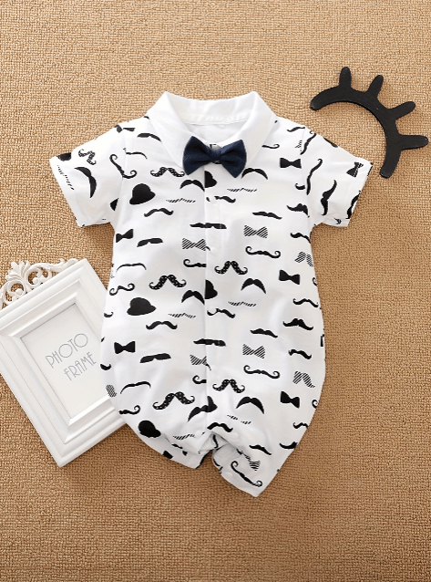 Baby romper with mustache and bow tie pattern on a beige background