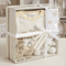 Baby gift set with clothes and toys in a transparent box, branded 'Kris x Kids'.