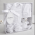 Baby gift set with white baby clothes and a toy in a box labeled 'Amore'.