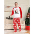Man wearing Christmas-themed pajamas with a festive design in a living room.