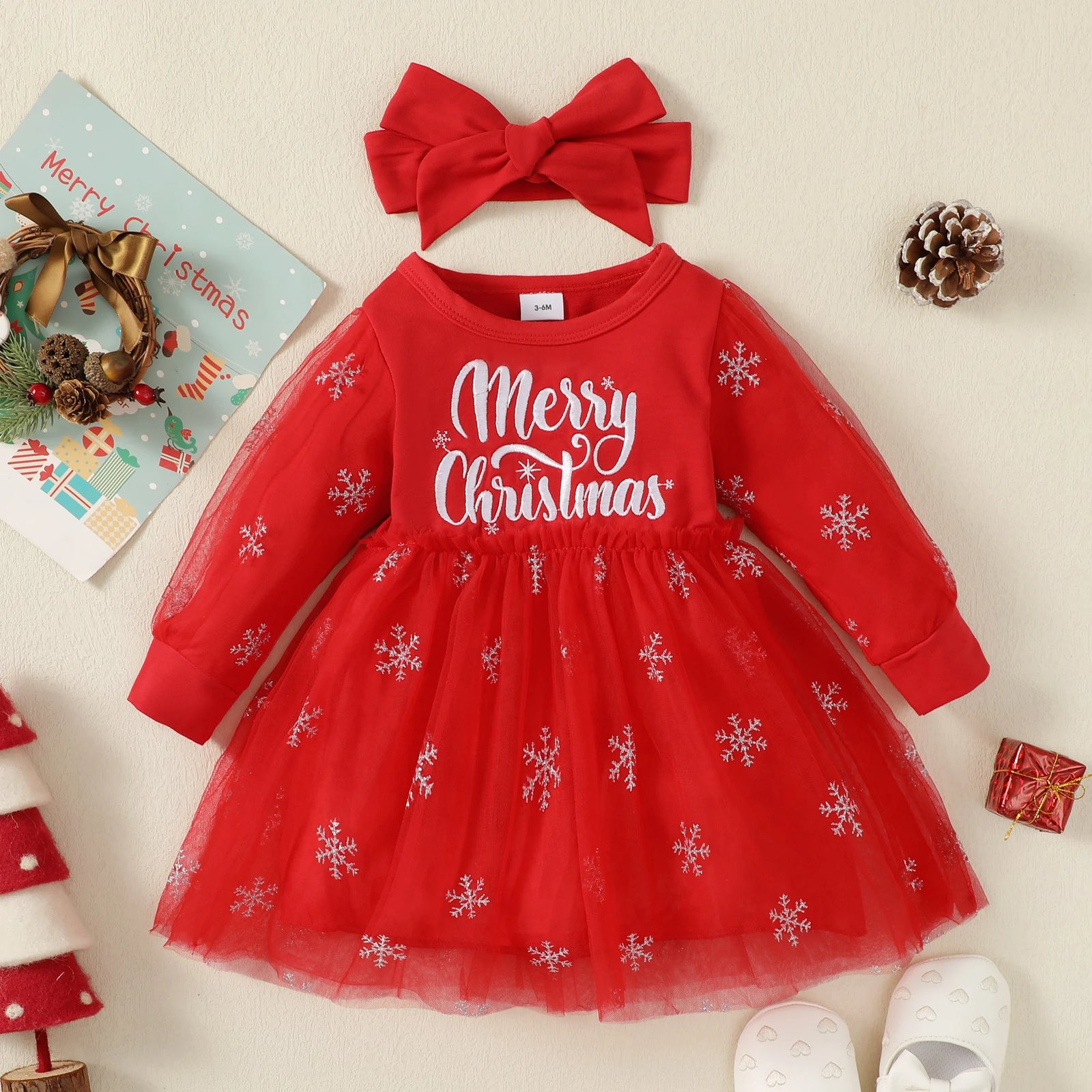Red Christmas dress with snowflakes and a matching headband on a light background.