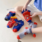 Spider-Man themed socks on a table with a person wearing one of them.