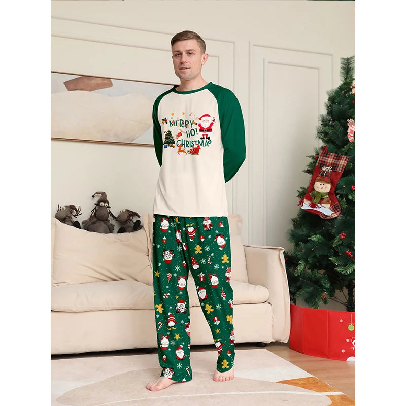 Man wearing Christmas-themed pajamas in a living room with a decorated tree.