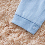 Light blue fabric with a button on a beige textured surface