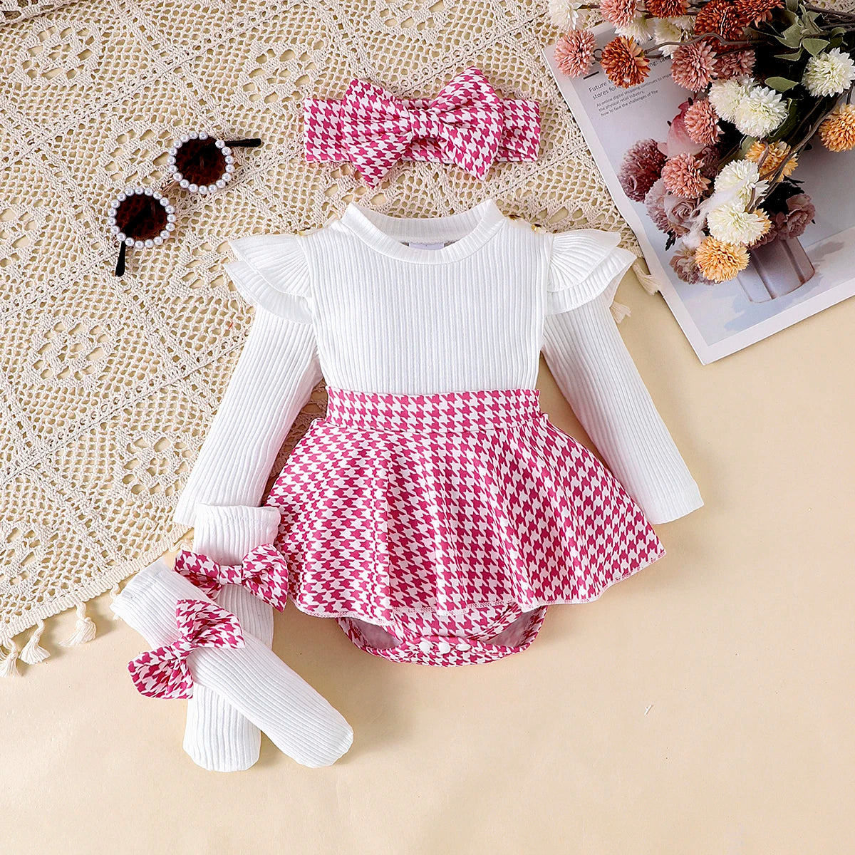 White long-sleeve top and pink houndstooth skirt set with matching headband on a textured surface.