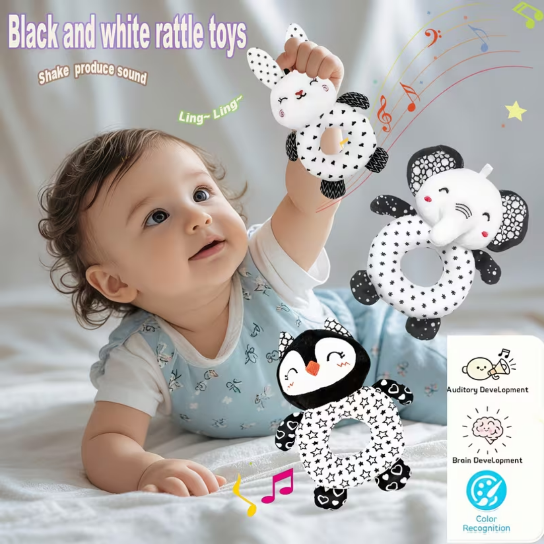 Baby playing with black and white rattle toys on a light background