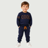 A young boy wearing a navy blue two-piece tracksuit with brown and orange accents, standing against a light gray background.