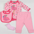 A baby clothing set laid out on a white background, including a pink long-sleeve romper with flamingo print, matching pink pants, a pink bib with a flamingo applique, and a light pink sock.