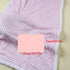 Pink textured blanket with measurements on a light background