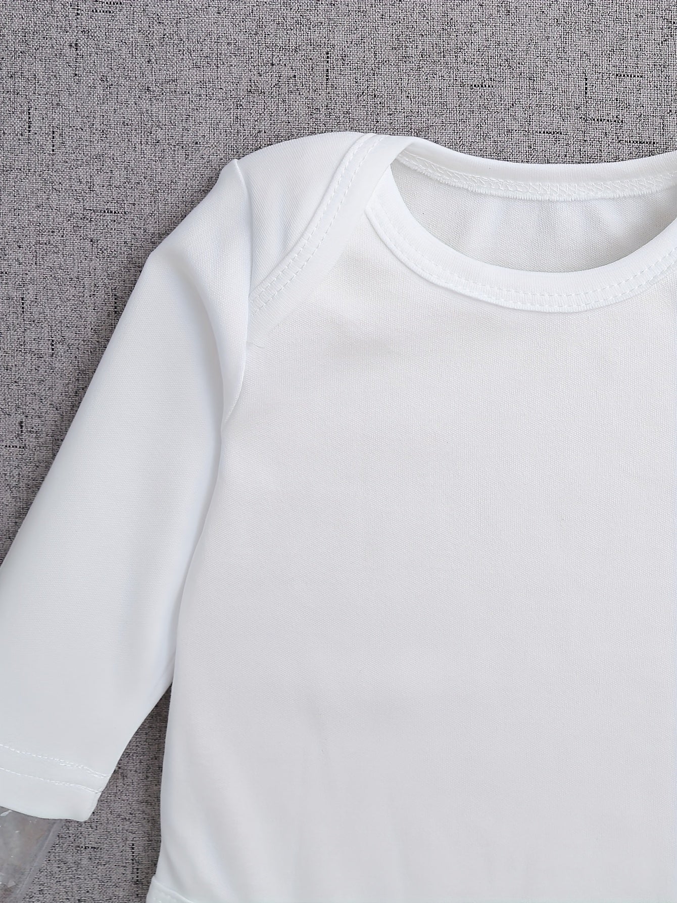White long-sleeve shirt on a textured gray background