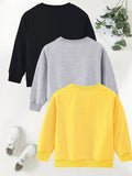 Three sweatshirts in black, gray, and yellow on a white background with sneakers and greenery.