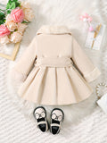 Beige coat with white fur collar on a textured surface with flowers and accessories.