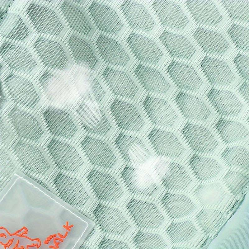 Close-up of a textured green fabric with a small red logo in the corner.